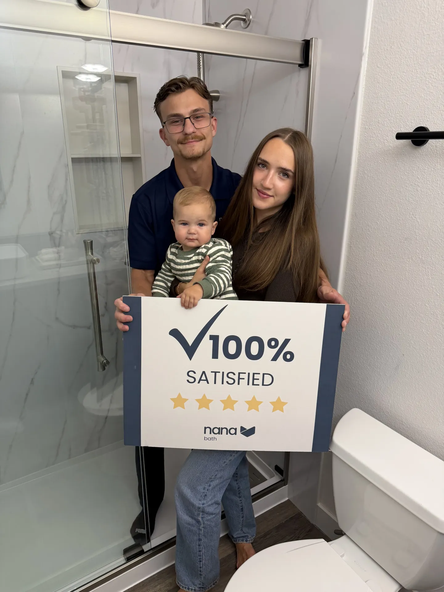 Max and Angelika with their baby in front of their new walk-in shower in Everett
